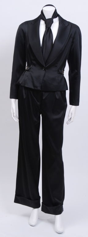 Three piece silk satin stretch pantsuit. This material contains 2% spandex to give it a clean, comfortable shape. Wide leg cuffed trousers sit just above the hip. The single breasted blazer is tapered at the waist, with adjustable lacing at back.