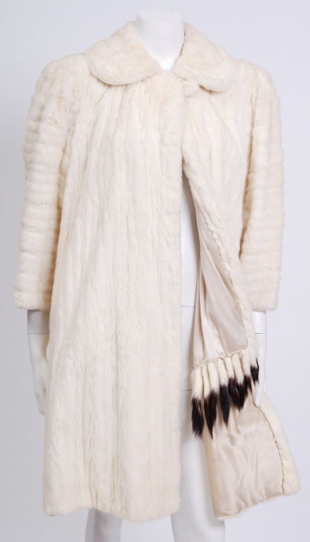 Luxurious, soft, supple cream colored ermine coat, lined in cream silk satin, decorated in the interior with a row of ermine tails. Feels like a bathrobe on. Kept in mint condition. No wear to the fur.