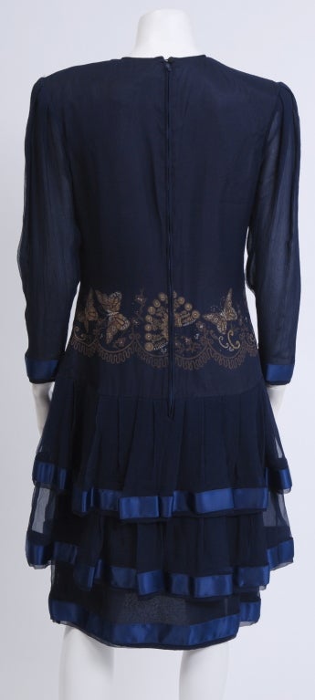 Very unique blue silk dress, embellished with silk screened gold butterfly motif decorated with rhinestones. Simple shape, long sheer sleeves and tiered skirt, edged with satin ribbon. Fully lined in silk.
