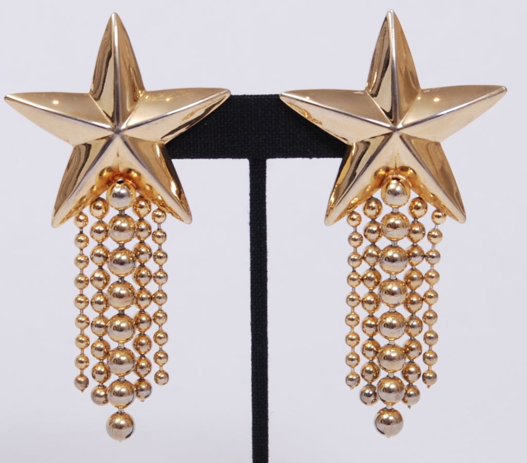 Large, exaggerated shiny star ear-clips. Ball and chain fringe attached to hollow pressed mixed metal stars.
Easily converted to posts.