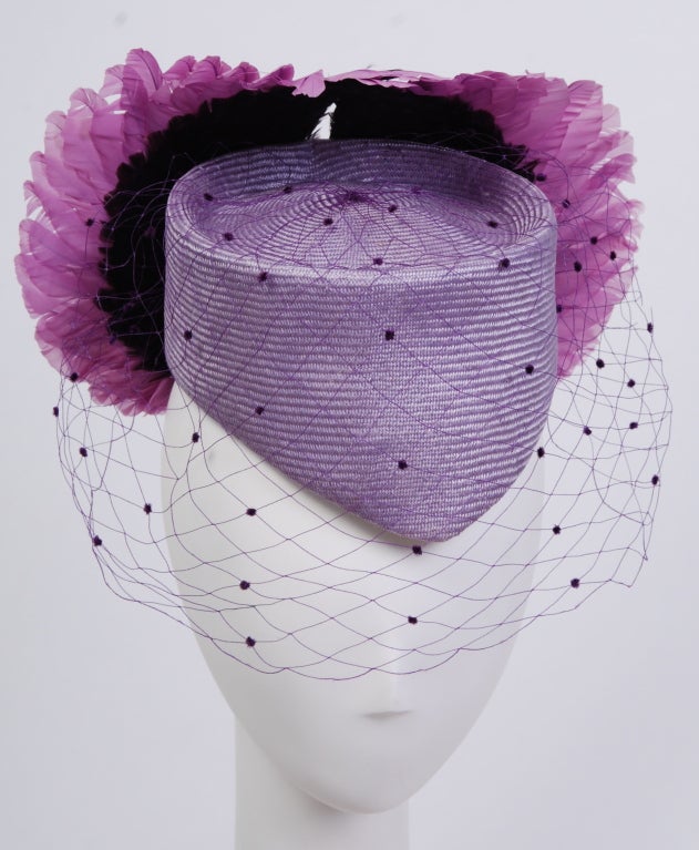 Stunning, one of a kind Jack McConnell straw and feather hat. Trimmed with purple netting and decorated with two toned mauve and iridescent purple feather wings. 
Packed in original box with notes for the buyer.