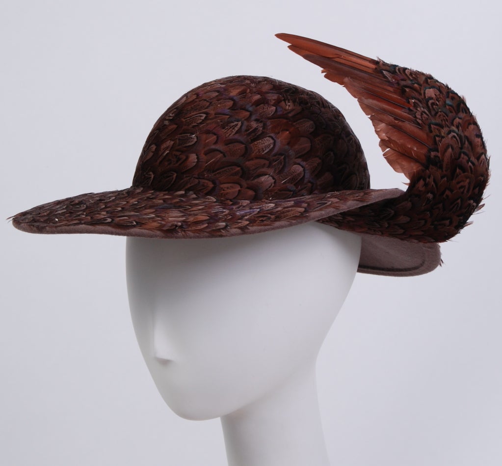 Outstanding brown felt, wide brimmed hat with curved wing. Completely embellished with layers of brown and opalescent feathers. Kept in pristine condition.