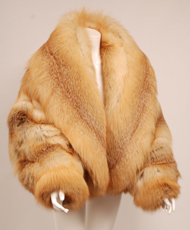 Volumptous golden fox fur jacket. Exaggerated, glamourous cut with an extra large cape collar and dolman sleeve. Kept in pristine condition. 
This statement fur is a larger cut but looks beautiful and ultra luxurious on almost any body type.