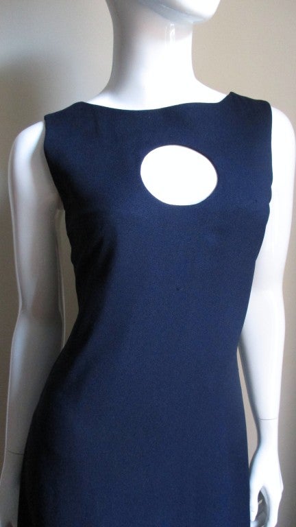 From Pierre Cardin a navy blue crepe full length dress with a circle cutout at the chest.  The neckline is a bateau from the front with the shoulders forming staps in the back which attach with self covered buttons to a square cut mid back.  The