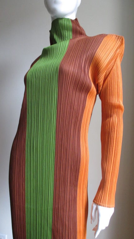 A beautiful color blocked maxi dress by Issey Miyake's Pleats Please line in green, chocolate brown and orange.  It has a stand up collar and square cut shoulders from which full length panels of color emanate.  It is unlined and slips on over the