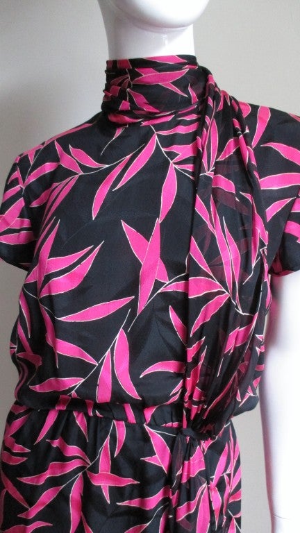 Beautiful silk dress from Valentino. It is a leaf patten silk in vivid pink over top the same pattern embossed black background.  Catches the light beautifully and adds a depth and richness to the dress. The short sleeved blouson bodice has an