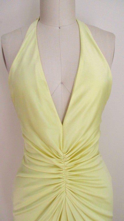 A great dress from Versace in soft lemon silk jersey. The label photo close up is the best representation of the color.  It has a flattering plunge V neckline in the front and ruching at the center waist enhancing the fit.  The center front hem