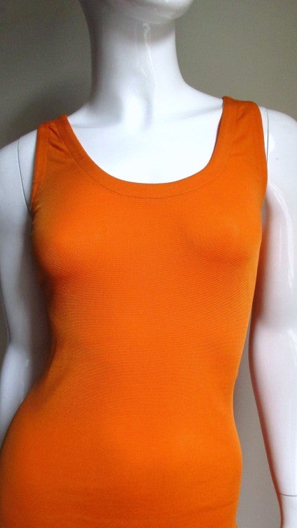 A simple dress in a perfect orange synthetic knit from Gianni Versace.  Front scoop neck fitted through the hips and then a small flare to the hem.  The back is low cut.  Slips on over the head and is unlined.
Excellent condition, unworn condition.