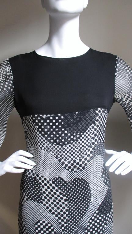 A silk maxi dress from Pierre Cardin in a black and white abstract shapes filled with various sizes of dots and squares.  The dress has a black silk yoke that comes to the bust level front and back.  The bell sleeves are one layer of the fabric, the