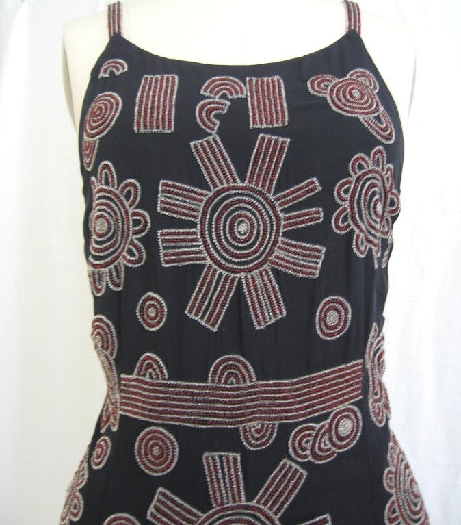 Beautifully beaded in clear and burgundy glass beads forming intricately detailed patterns of circles and lines on navy silk. Low back with zipper, shirttail hem and fully lined in the same navy silk.  Absolutely beautiful. 
Excellent, appears