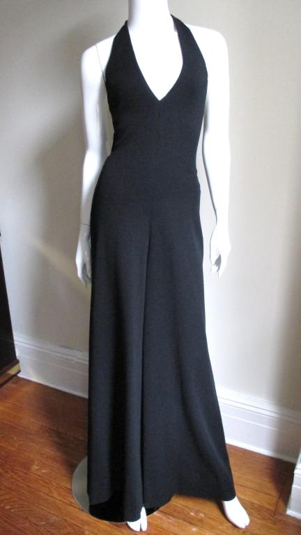 Incredible 3 piece set from Halston.  Wide leg halter jumpsuit, open style straight cut jacket and obi tie belt all in medium weight black wool jersey.  Jumpsuit has a plunging neckline, closes at the neck with hooks, has a back zipper at the waist