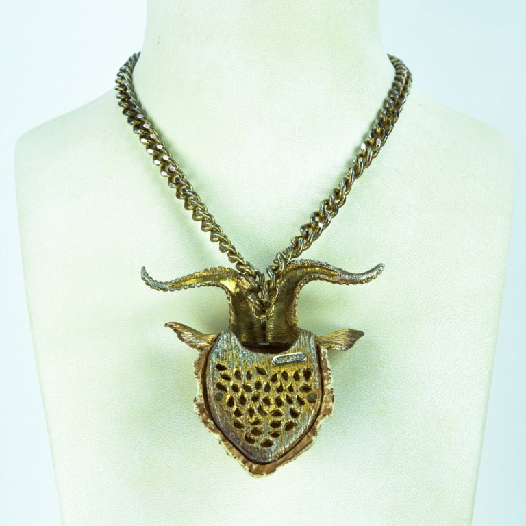 Fabulous signed Razza Zodiac Pendant featuring the Capricorn Goat Head, crafted by famed designer Luke Razza; the goat’s face is cast of ivory resin and is backed by gold-tone metal; Goat’s horns, ears and eyes are also of gold-tone metal. The back