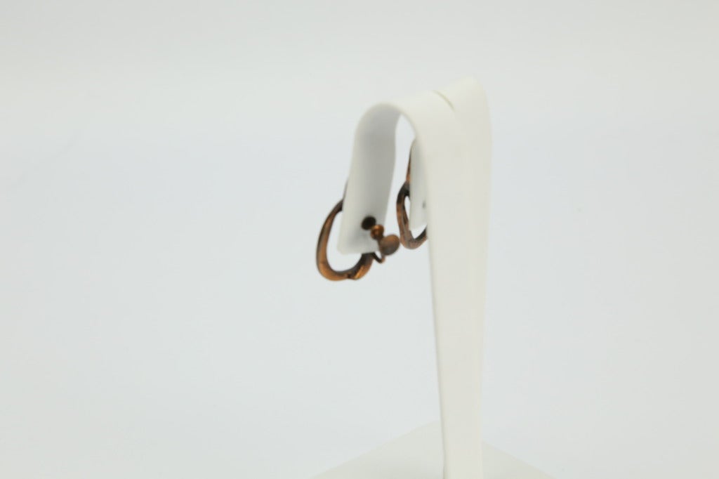 Modernist Flame Pendant Copper screw back Earrings, each measuring approx. 1.25” long, signed: REBAJES; by famed Mid-Century Dominican-Manhattan jeweler, Francisco Rebajes. 

