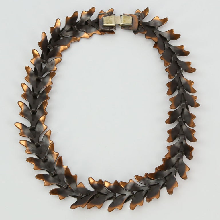 Collana modernista in rame con foglie a cascata collegate; chiusura a scatola invisibile; firmata REBAJES. Misura circa 15,5