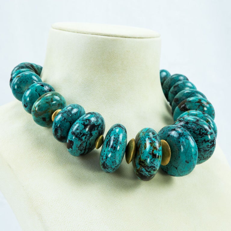 Sensational Genuine Turquoise Necklace, comprising 27 graduated rondelle shaped Turquoise beads, each approximately 19.25mm-42mm, inter-spaced with gilded Sterling Silver rondelles held by a unique spiral clasp; Hand strung. The necklace measures