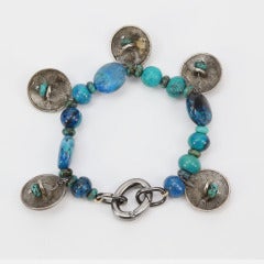 Awesome Turquoise and Silver Bracelet and Earrings. Bracelet features assorted Turquoise shapes and sizes inter-spaced with Silver Indian Head discs. Indian Head drop Earrings compliment this ensemble. Hand crafted; approx. 17 inches long. Companion