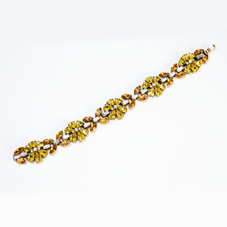 A Beautiful and rare signed 1940s Trifari Crystal Floral Twinkle Bracelet, encrusted with sparkly clear, citrine and topaz crystals, encompassing baguettes, teardrops and rounds;  lovely, tight fold-over clasp;  marked: TRIFARI with a crown and