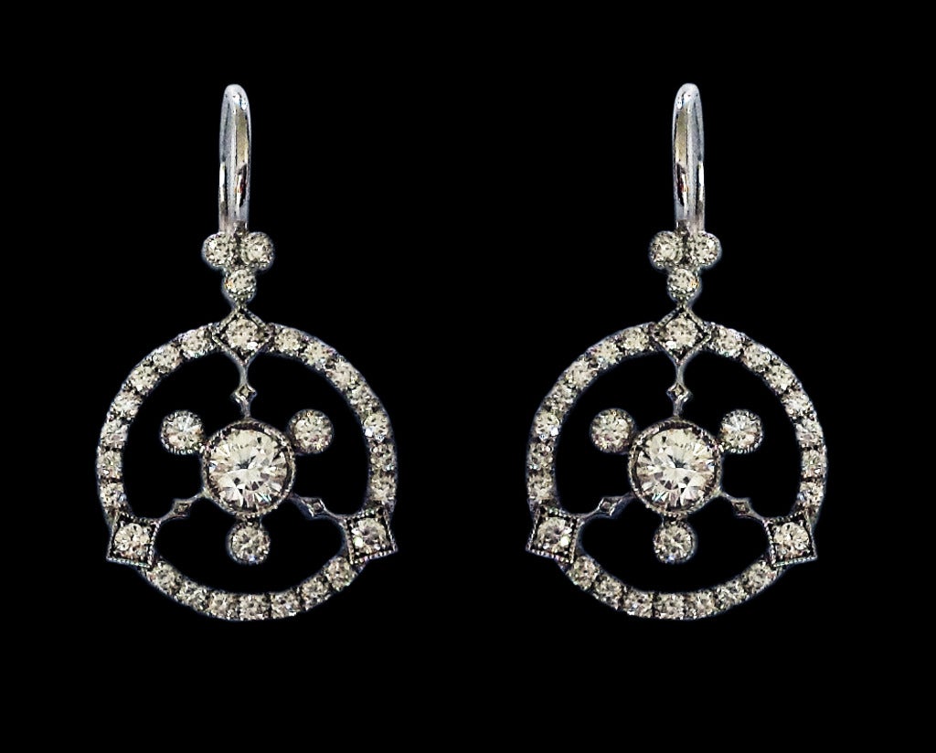 Boucles d'oreilles pendantes en or blanc 18 carats serties de diamants avec au centre deux diamants ronds de taille brillant pesant 0,40 carats entourés de diamants ronds de taille brillant pesant 0,82 carats de couleur F-G et de pureté VS.poids