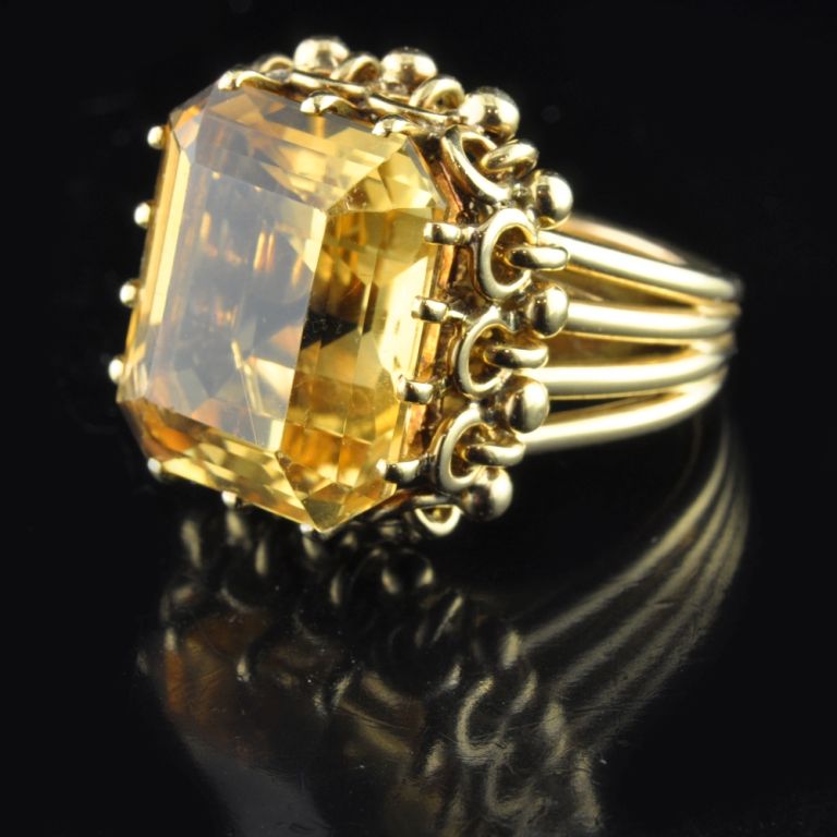 PLEASE NOTE: OUR PRICE IS FULLY INCLUSIVE OF SHIPPING, IMPORTATION TAXES & DUTIES

Elegant cocktail ring set with a large emerald-cut citrine in a decorative yellow gold mount to split yellow gold shoulders and shank, Boucheron, Paris, circa 1940s