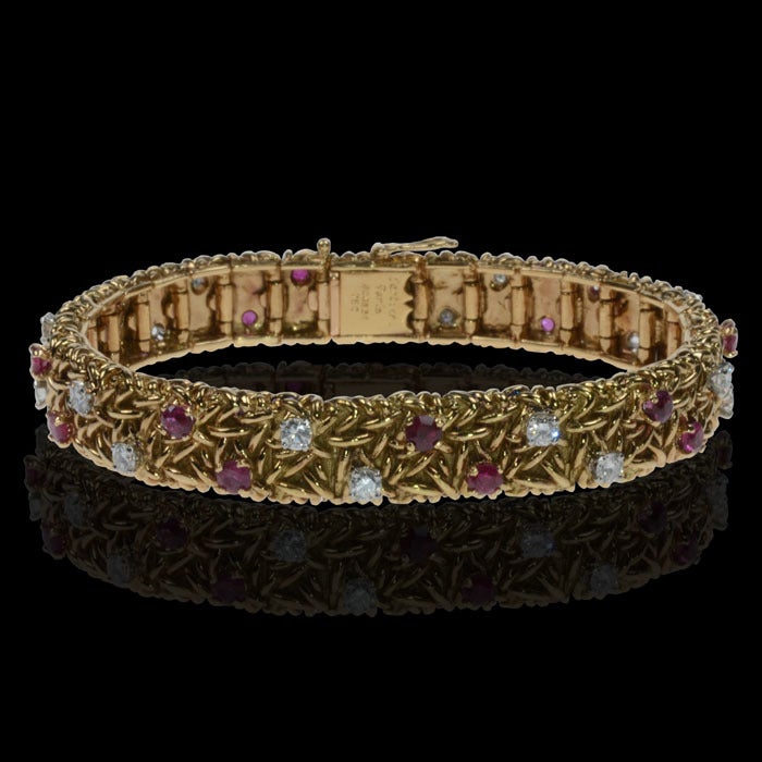 PLEASE NOTE: OUR PRICE IS FULLY INCLUSIVE OF SHIPPING, IMPORTATION TAXES & DUTIES

Elegant 18ct yellow gold textured strap bracelet set with two rows of alternating brilliant-cut diamonds and rubies, Cartier, Paris, c1975
Length 7 inches