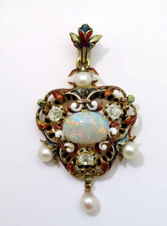 Beautiful 19th century pendant set with a fine opal weighing 5.05 carats, mounted in 18 karat yellow gold, and embellished with multicolored enamel. The opal displays an exceptionally strong play of color. Surrounding the opal are three old mine cut
