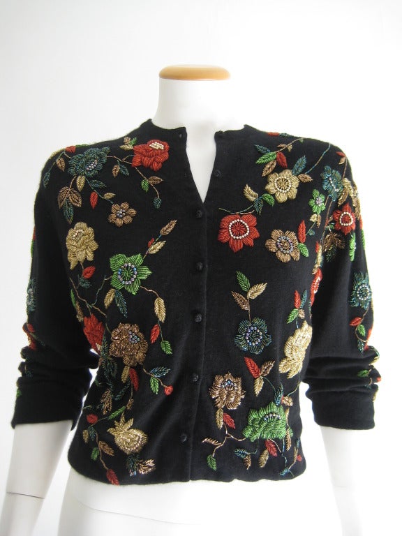 1950s Black Cashmere Sweater with amazing multi colored beadwork on entire sweater (front and back and arms). Beautiful black corded buttons. Fully lined. Lighting in photo is bright and may make sweater appear slightly lighter than it is in person.