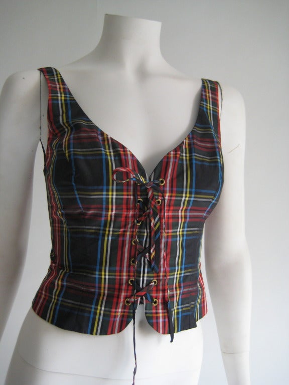 Late 80s/ early 90s. 100% Silk. Plaid Bustier. Lace up front. Hook and eye along entire back. Zip up back. Fully lined in black. Tag reads US 6, Italian 40.