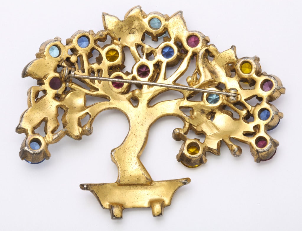A cheerful, large and very pretty gilt metal brooch, as a flowering miniature tree in formal pot, with enameled accents, set with lively colorful crystals. Pin back. 2 1/4 inches x 3 inches. Unsigned. Purchased from the famous Norman Crieder shop at