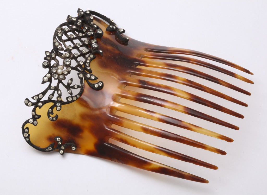 An elegant c.1900 hair comb of faux tortoise mounted with a scrolling openwork silver detail  set with French paste brilliants. 3 1/2 inches x 4 1/2 inches. In original silk lined presentation box, with New York jeweler's address.