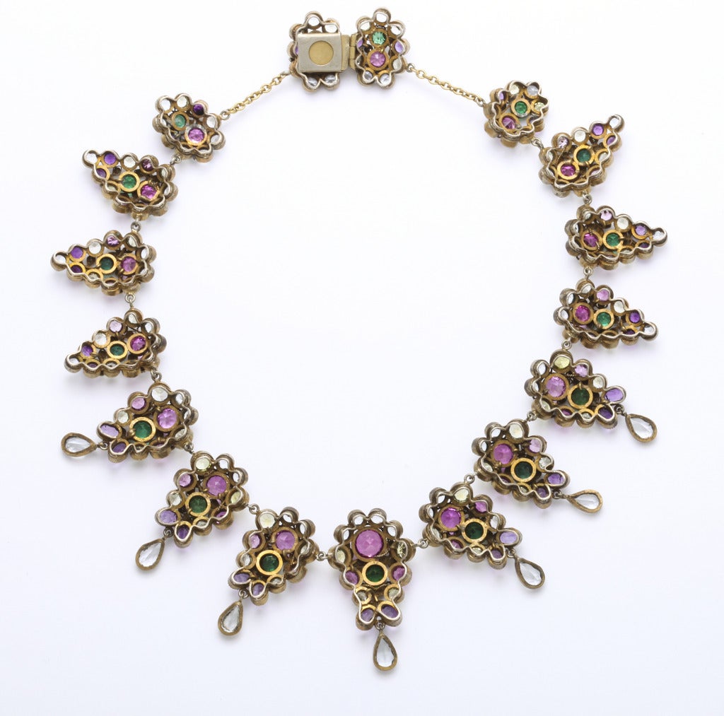A regal 1930s unsigned necklace undoubtedly by Hobe, of silver and gold colored metals set with multicolored crystal stones, finished with a delicate filigree floral design overall. Fits a 15 inch neck, but can easily be lengthened with chain.
From