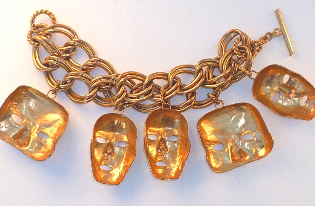 From the1989 Isabel Canovas Commedia Dell' Arte Collection, a sumptuous gold plated brass charm bracelet of two chainlinks wide, hung with five Venetian masks as charms. Toggle clasp.
Length 8 inches. Larger charms 2 inches. Bracelet width