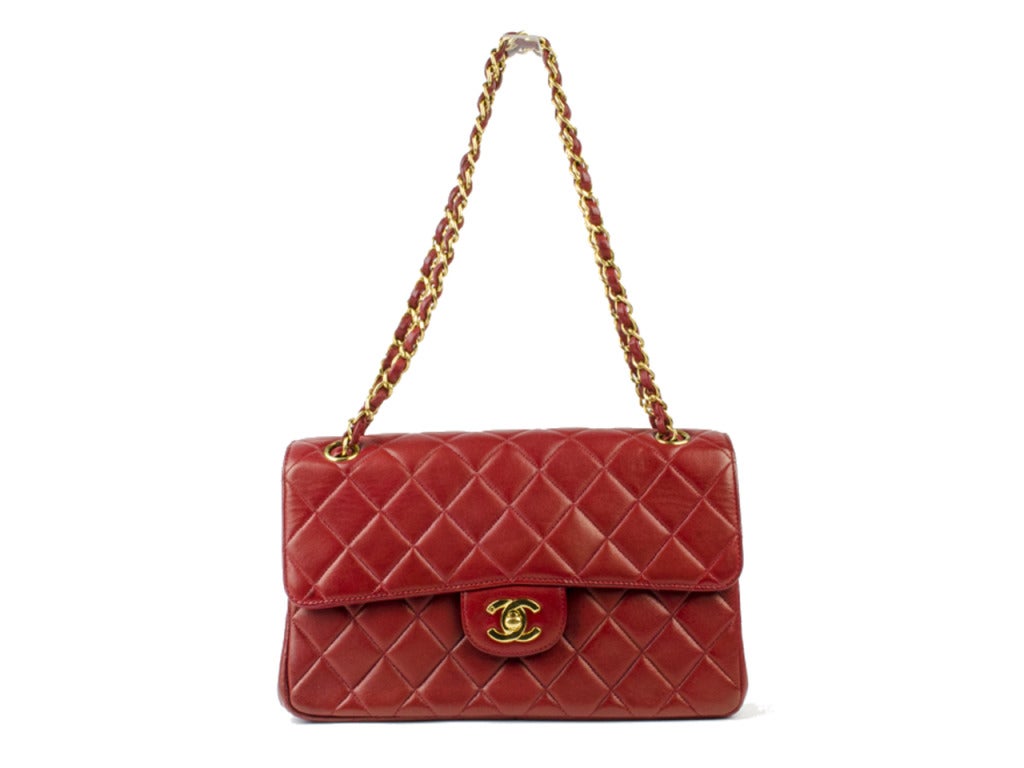 This is an authentic vintage Chanel Lambskin Double Sided Flap in Red. The elegant design and classic quality of this Chanel flap bag lend a chic look of sophistication for day or evening. Absolutely stanning flap with a Mademoiselle turn locks on