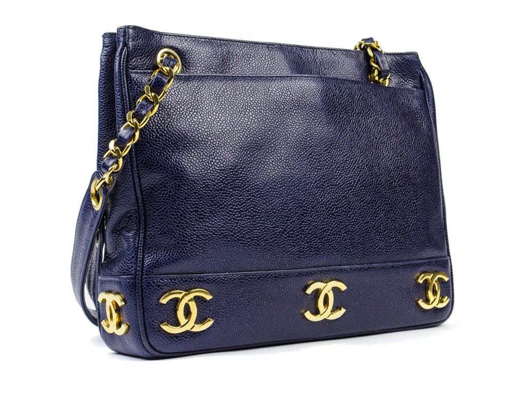 Stunning bag for everyday! Chanel navy blue caviar leather is adorned with iconic interlocking 'CC' in gold tone hardware throughout the bottom perimeter of the front and the back of the bag. Absolutely gorgeous in an extremely rare color!