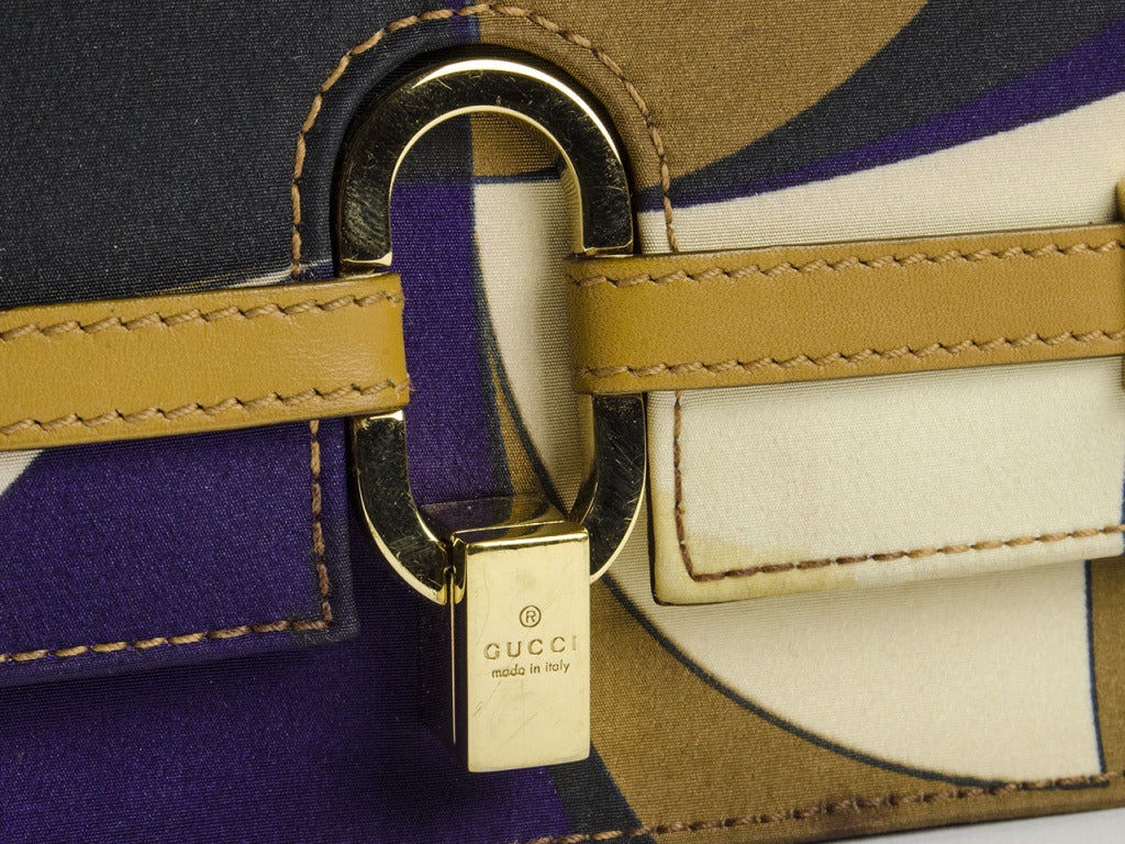 Stunning! Gucci evening satin bag featured in gorgeous hues of eggplant purple, black, brown and cream with Gucci signature throughout. Leather detail at front as well as the shoulder strap. Interior features one zippered pocket.