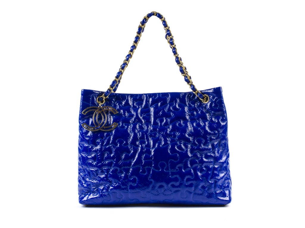 Strike up your wardrobe with the Chanel blue puzzle tote. A flash of royal blue, hint of patent shine and whimsical puzzle embroidery bring a playful vibe to this medium-sized, multipurpose tote. Perfect for a fun lunch date with the girls or
