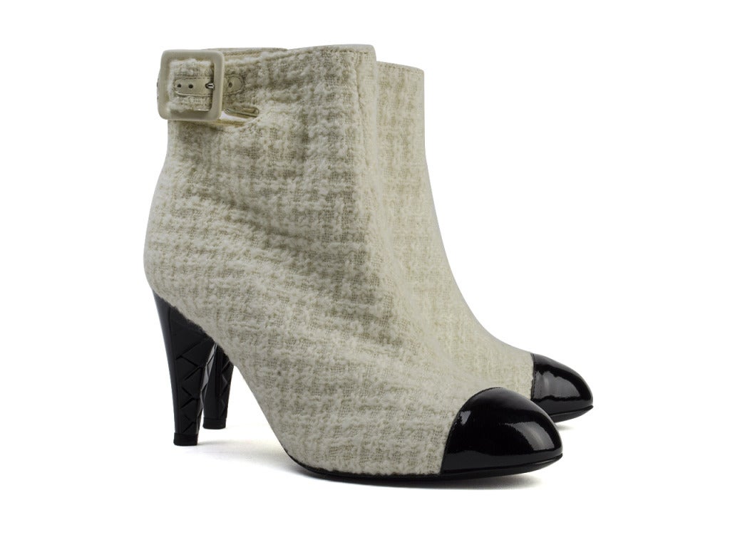 Add a romantic statement to your favorite peacoat and tights with the Chanel ivory boucle booties and hit the town for a night of warm nightcaps and good cheer. Black patent cap toe and heel with quilting detail underneath add dramatic flair to the