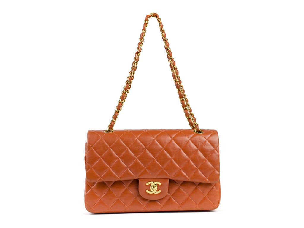 The buttery soft quilted leather and vibrant orange of this Chanel flap bag will drive you wild! Slip onto the shoulder of a leopard print dress or navy blazer for a sophisticated pop of color and class. Iconic bag features gold interlocking CC