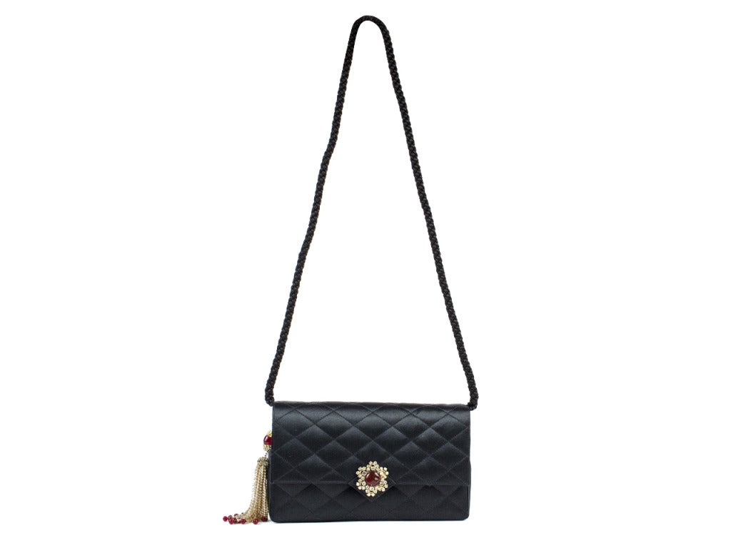 Stay decadently sweet through the winter with the Chanel jeweled satin bag. Quilted satin culminates in pointed flap closure with bejeweled floral brooch at front and interlocking CCs embroidered at bottom. Side tassel features more jewels and