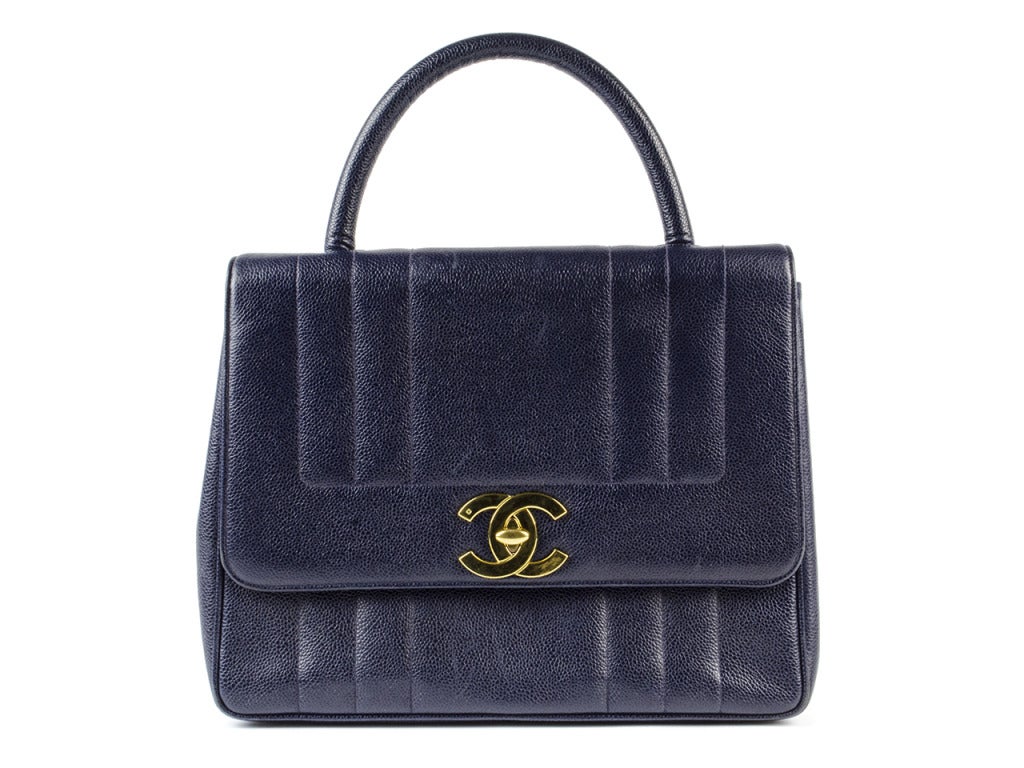 That interview for CEO will be a piece of cake with the Chanel blue Kelly top handle bag on your arm. Pebbled leather with thick-striped embroidery and a large flap with gold interlocking CCs at the turn lock give this briefcase-style bag timeless