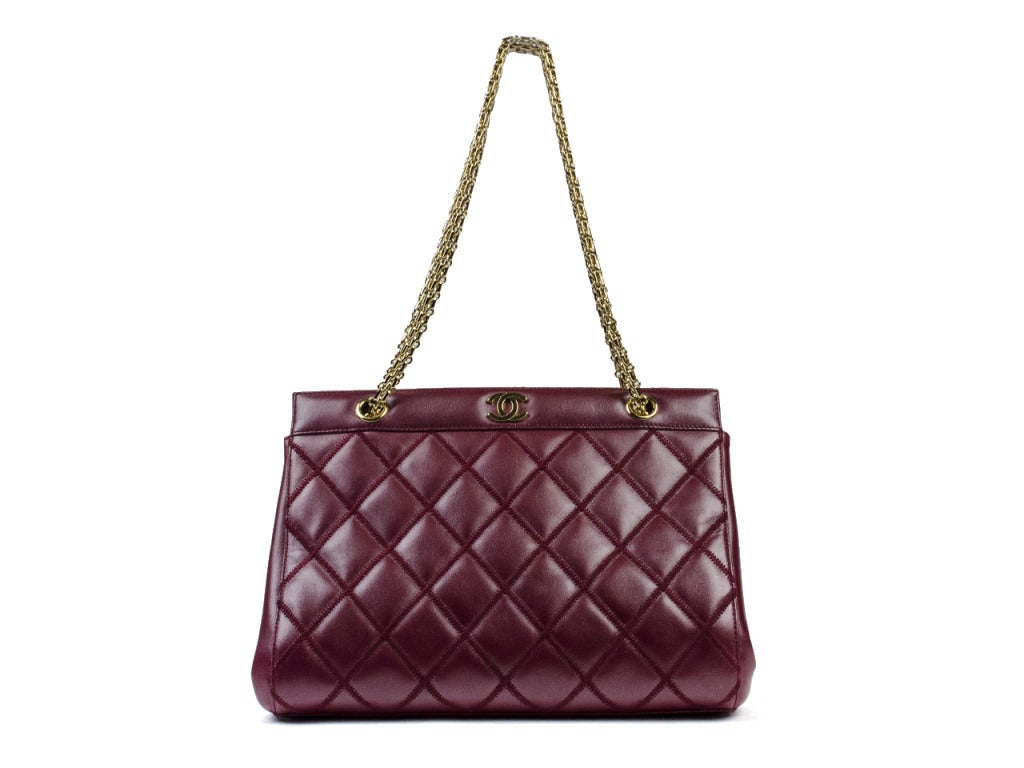 Perfect for an evening out! Chanel deep red shoulder bag is adorned with red quilted detail throughout, lambskin leather, gold tone interlocking CC at closure, gold chain shoulder bag. Interior features three separate pouch pockets, magnetic closure