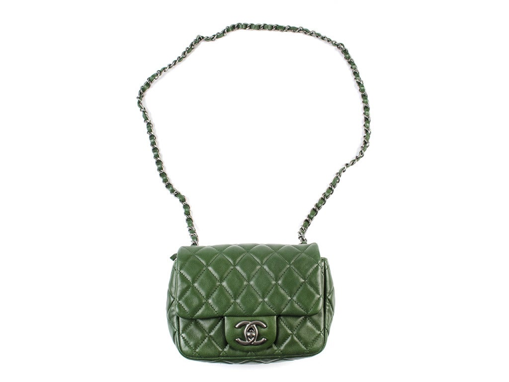 Tap into your inner trendsetter and make green a neutral in your wardrobe with the Chanel green lambskin mini flap. Quilted lambskin leather in deep army green and slate metallic accents pair perfectly in this compact 6.5