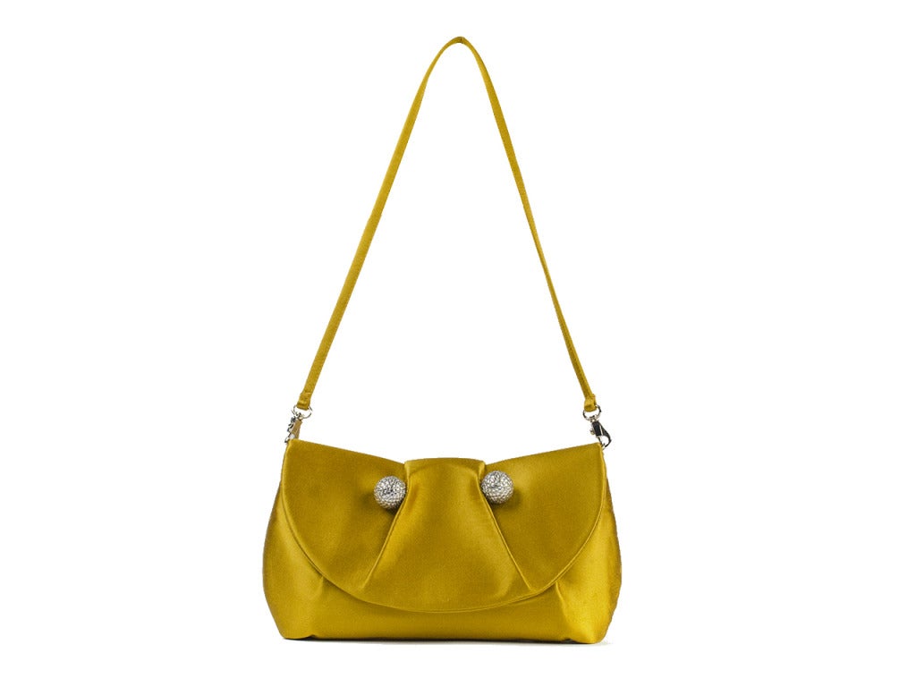 You knew Christian Louboutin created exquisite red-bottom heels, but you'll also fall in love with his talent for handbags when you slip the strap of the mustard yellow satin clutch over your shoulder. Deep mustard yellow satin exterior with