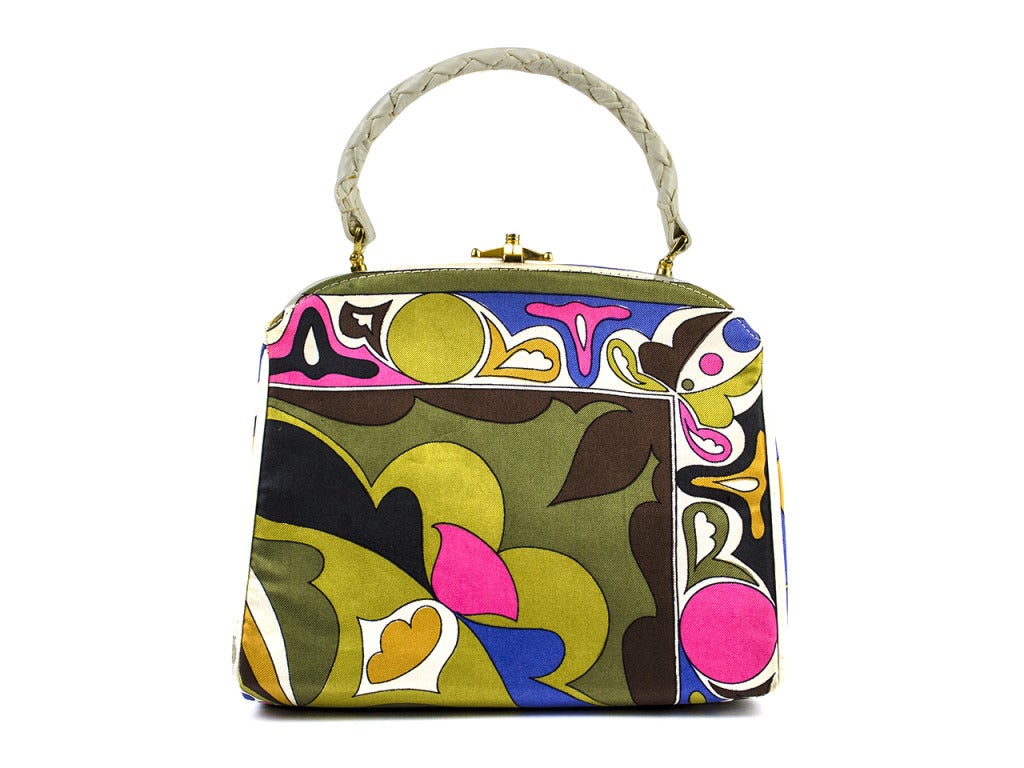 An undeniably Emilio Pucci print highlighted with white leather piping and braid strap give this vintage top handle bag a whole lot of fun. Features gold hardware and the stand-on-its-own structure we require from any good vintage bag. Item is in