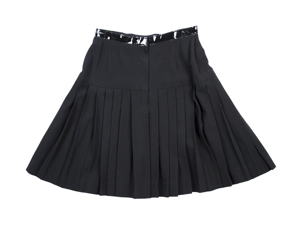 Pull the Chanel black skirt over an oxford blouse and pullover sweater combo for a professional ensemble with a hint of patent pizazz. A-line skirt features pleats throughout and patent-leather-style trim on waistline. Just slightly damaged on