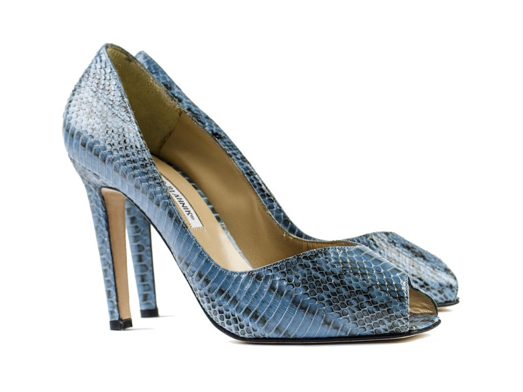 Sophisticated yet saucy peep toes don't get much better than this! The Manolo Blahnik blue snakeskin peep toe heels feature light blue and black snakeskin-treated leather with triangular peep-toe and romantically round cut at vamp. A perfect