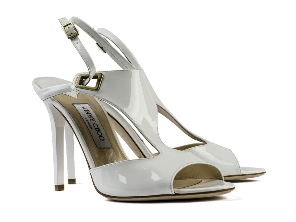 A grown-up T-strap heel picture perfect for evenings on a cruise ship or other upscale places to see and be seen along your favorite coast. The Jimmy Choo 'Elle' white patent leather heeled sandals feature round peep toe cutouts and thick T-straps