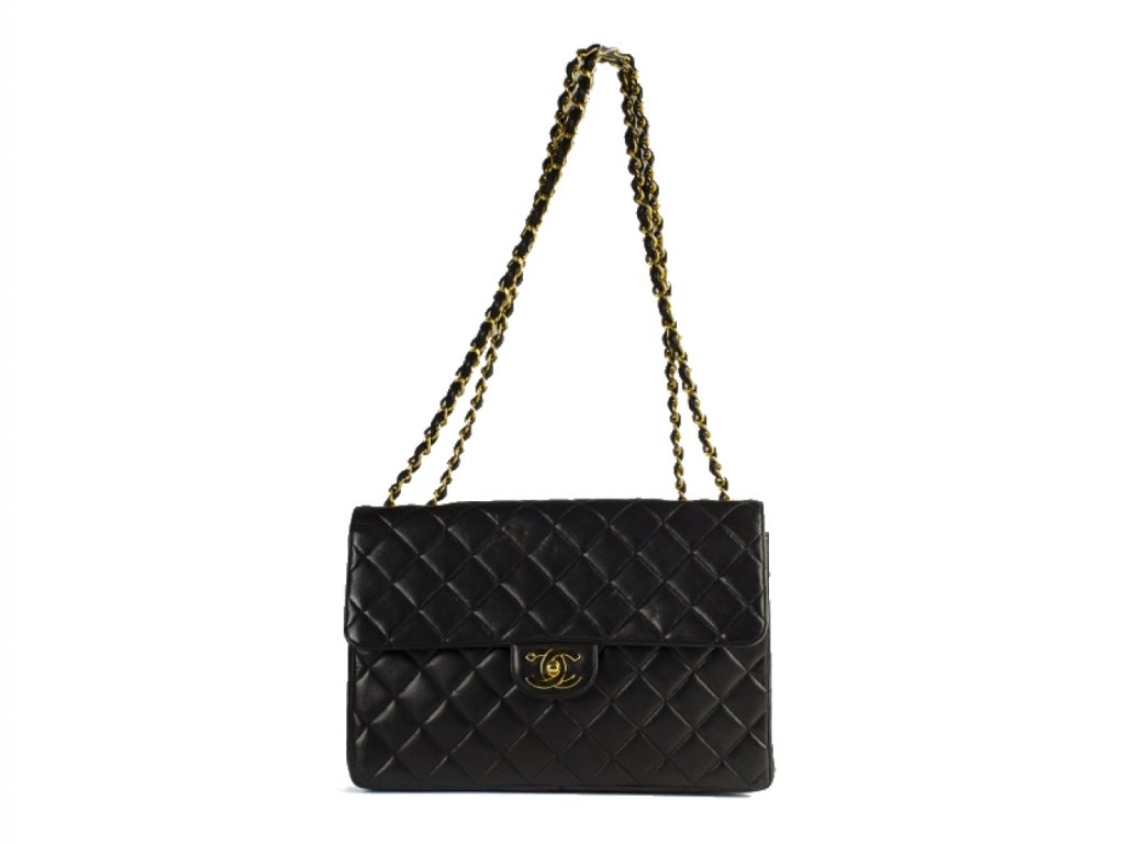 A collectors dream! CHANEL 2.55 Jumbo flap in black lambskin features quilted diamond pattern throughout with contrasting gold hardware. Exterior features pouch pocket at back. Interior features one pouch pocket and one zip pocket. Good condition