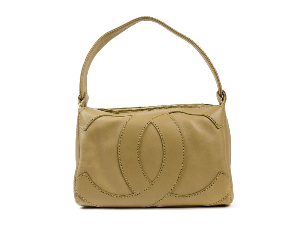 Perfect for lunch with the girls! Chanel shoulder bag is done in a beautiful beige with interlocking monochromatic ‘CC’ detailing, zip top, four feet at the bottom of the back. Interior of the bag two pouch pocket and one zip pocket. Strap drop