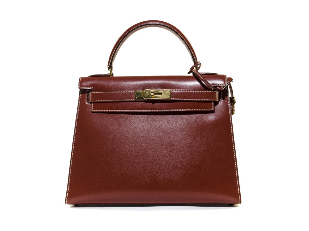 Warn by celebrities and even royalty, the Hermes Kelly bag is known by many as one of the most iconic bags carried on ones arm! This particular bag is a burnt red leather interior and exterior, with gold accent buckle and matching lock.