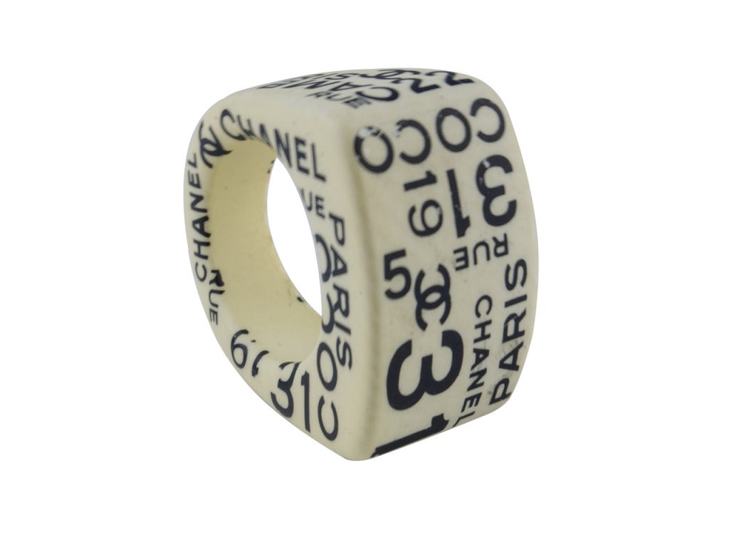 They'll know you mean business with the Chanel 02P Rue Cambon ring on your hand. Smooth wood is enveloped in a rich ivory color and stamped allover with 